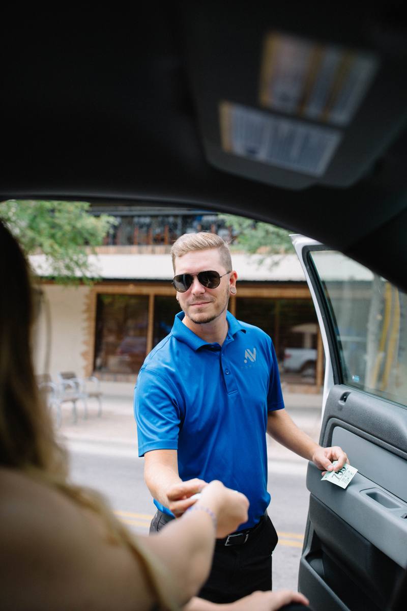 Valet attendant providing parking ticket to hotel guest